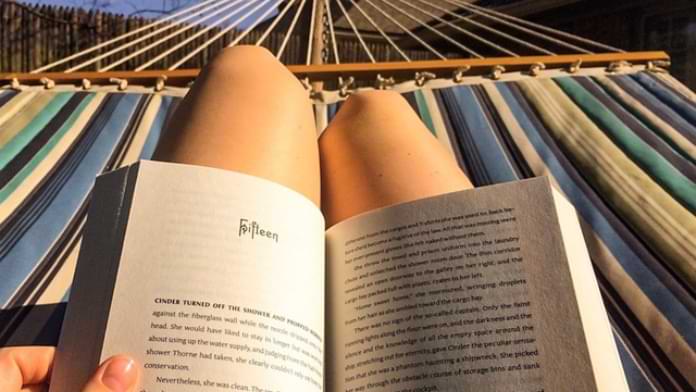 Knees in a hammock with an open books