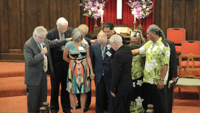 Scott and Rhonda Archer being prayed over during installation service