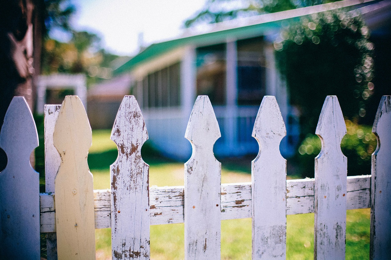White picket fence with yard in background